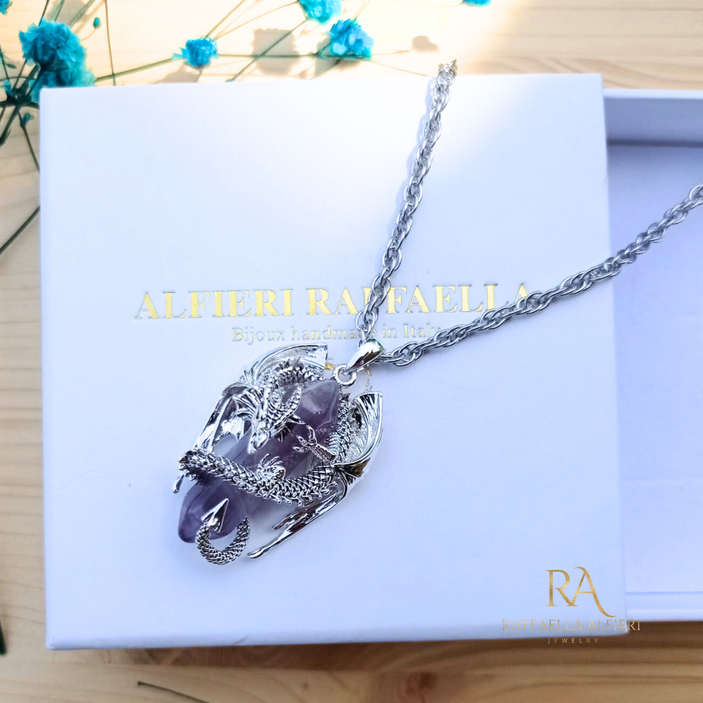 Collana fantasy unisex in acciaio con pendente 3D a forma di drago che avvolge nelle su spire un prisma di ametista naturale. La collana è durevole nel tempo, studiata per restare con te a lungo senza annerirsi mai.