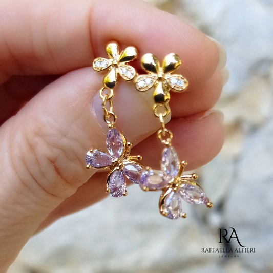 Piccoli orecchini pendenti a forma di farfalla con zirconi viola e perno a fiore