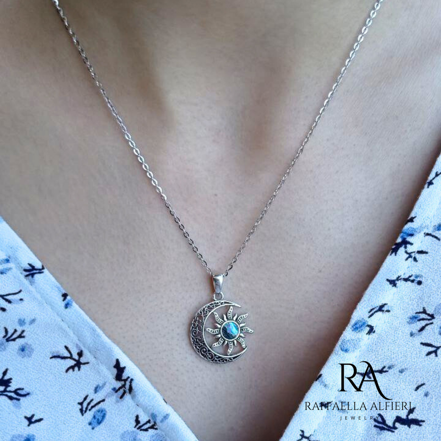 Collana in argento 925 anticato ispirata alla serie Dungeons & Dragons. La collana è in stile minimalista: la catenina è sottile e il ciondolo a forma di luna in filigrana d'argento contiene il sole al cui centro ospita un inserto di madreperla paua dai riflessi cangianti