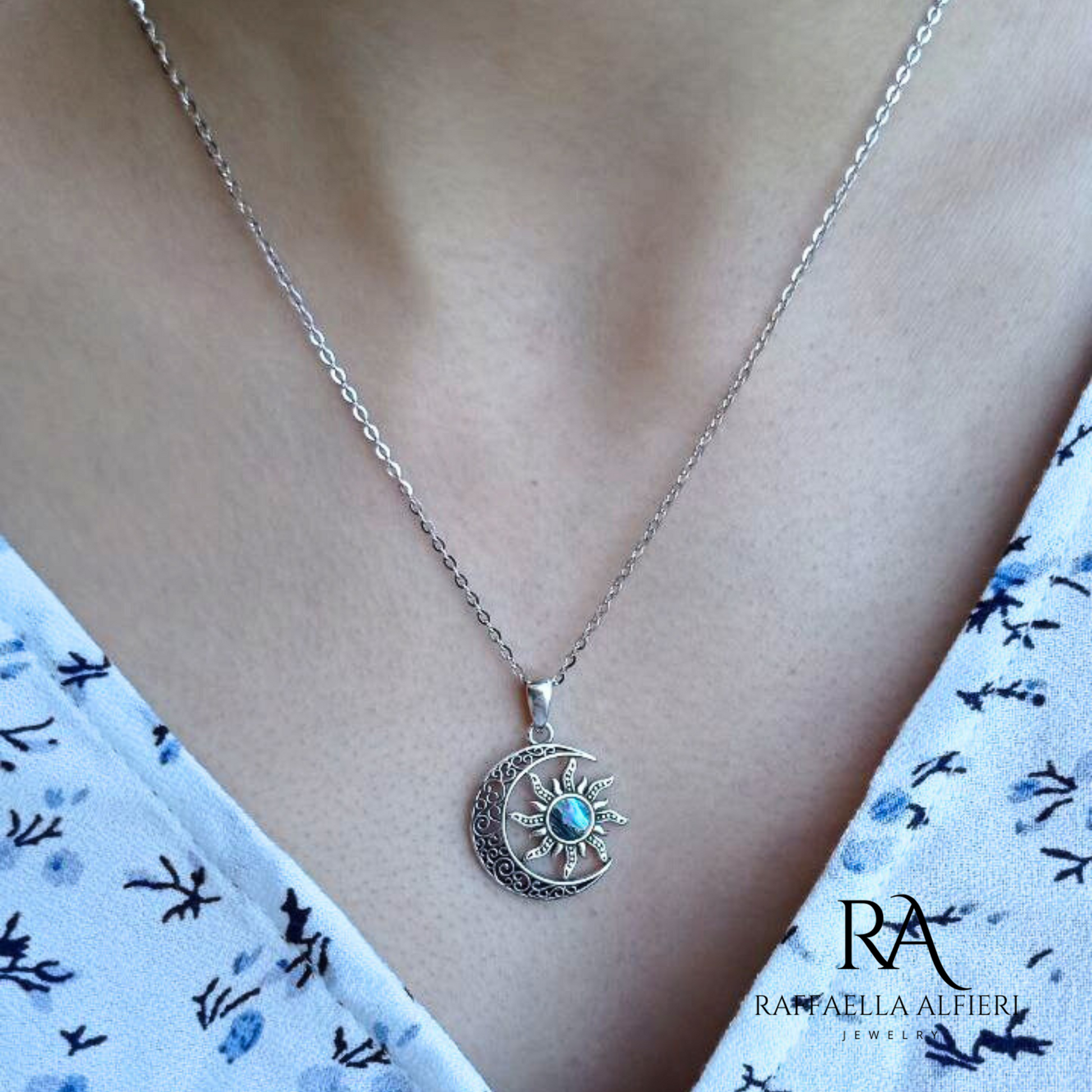 Collana in argento 925 anticato ispirata alla serie Dungeons & Dragons. La collana è in stile minimalista: la catenina è sottile e il ciondolo a forma di luna in filigrana d'argento contiene il sole al cui centro ospita un inserto di madreperla paua dai riflessi cangianti