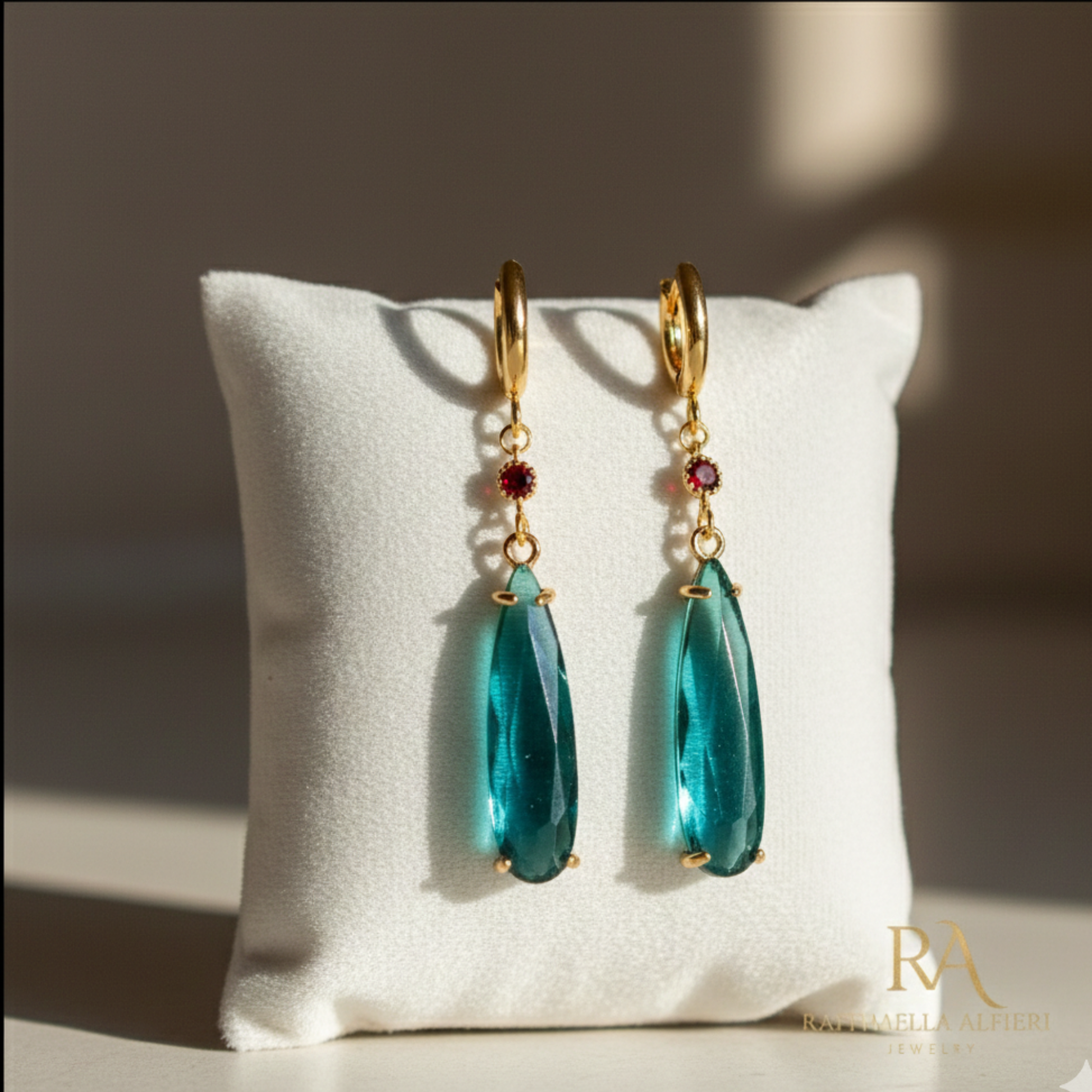 Coppia di orecchini a monachella dorati con goccia pendente verde smeraldo e piccolo cristallo rosso, ispirati al personaggio Howl de Il Castello Errante di Howl, gioielli cosplay eleganti.