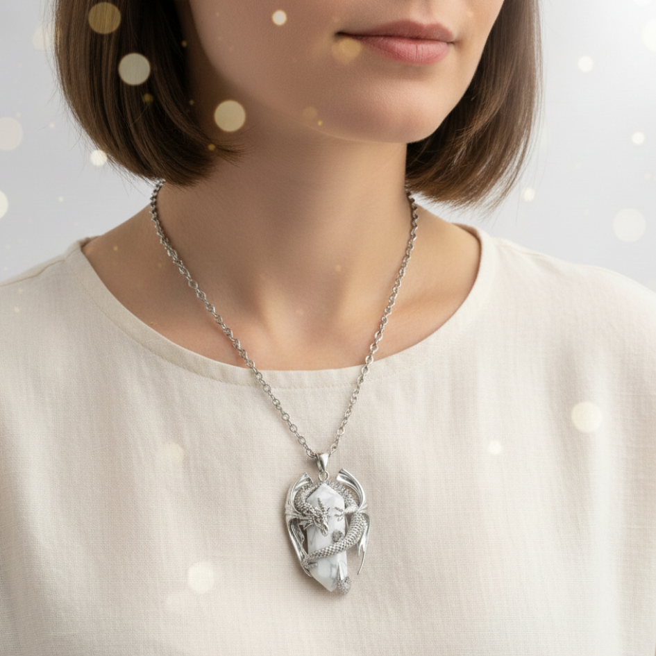 collana unisex in acciaio con ciodolo a forma di drago 3D in rame placcato argento 925 rodiato che avvolge tra e sue spire un prisma in Howlite bianca naturale. Ciondolo e catena in acciaio inossidabile. Simbolo di calma e protezione.