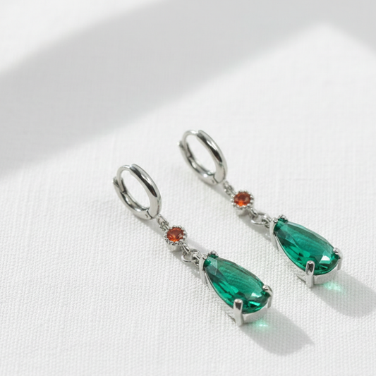 Orecchini ispirati ad Howl moving Castle dello studio Ghibli in acciaio color argento. Orecchini pendenti a goccia in cristallo verde smeraldo e zircone rosso. Gancio personalizzabile.
