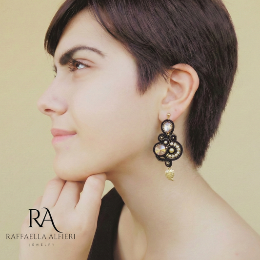 Orecchii neri e oro realizzati a soutache ed ispirati alla serie Bridgerton. Questi orecchini grandi e leggeri sono un tripudio di riflessi luccicanti di cristalli.  Vuoi passare inosservata? Con questi orecchini non ci riuscirai, nemmeno dietro ad una maschera!